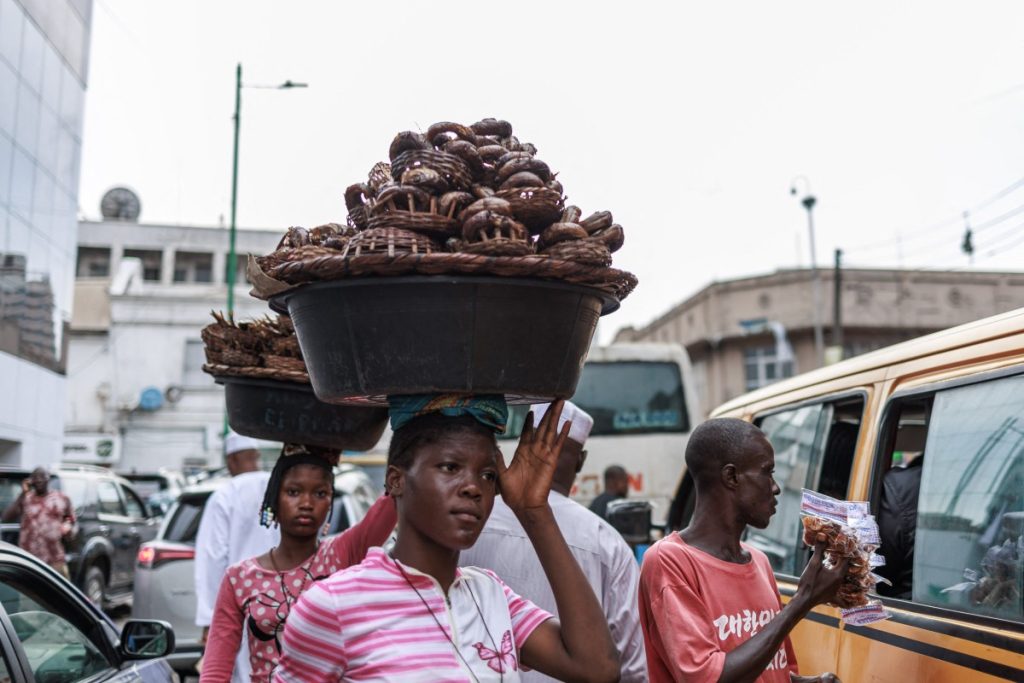 A vendor carries dried fish in a container at the Lagos island market in Lagos on March 8, 2024, ahead of the holy fasting month of Ramadan. (Photo by Benson Ibeabuchi / AFP)